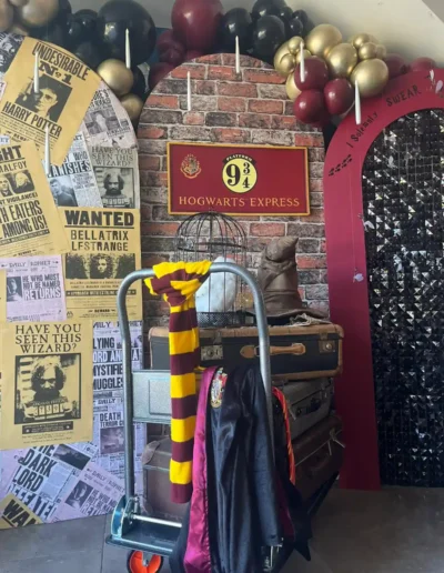 Harry Potter party scene with Hogwarts Express sign, trolley , Hedwig owl prop, sorting hat and scarf